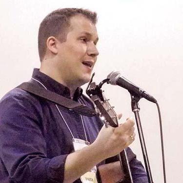 Photo of Marc Stockert singing and playing guitar